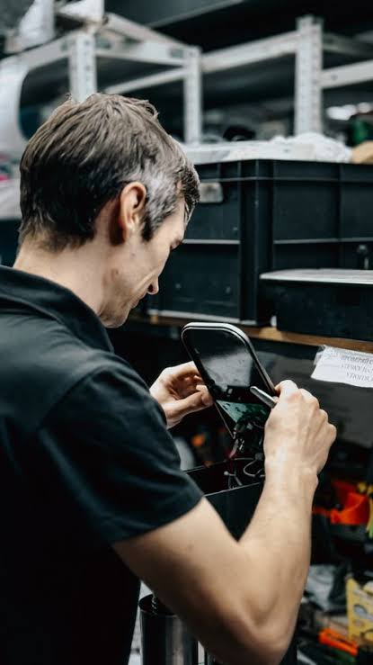 Technicien ajustant un équipement électronique dans un atelier